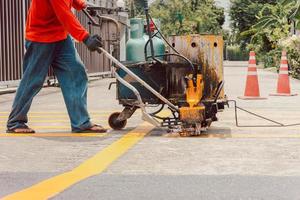 strada lavoratore dipingere traffico Linee su asfalto strada superficie. foto