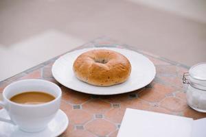 tazza di caffè con pane su tavolo nel il mattina con luce del sole, prima colazione foto