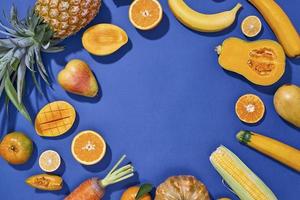 collezione di fresco giallo frutta e verdure su il blu sfondo foto