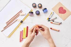 femmina mani Lavorando con polimero argilla. il processi di Lavorando con il plastica su un' bianca sfondo. foto