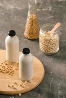 bottiglia di loto seme latte e soia latte su tavolo. foto