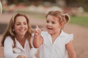 un anziano donna nel casuale Abiti con il suo figlia spende tempo insieme nel il parco su vacanza. famiglia volta. selettivo messa a fuoco foto