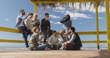 gruppo di amici avendo divertimento su autunno giorno a spiaggia foto