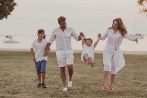 anziano coppia nel casuale Abiti con loro figli, ragazzo e ragazza godere il spiaggia la spesa un' vacanza insieme. famiglia tempo . selettivo messa a fuoco foto