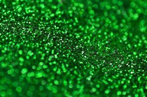 un' enorme quantità di verde decorativo paillettes. sfondo Immagine con brillante bokeh luci a partire dal piccolo elementi foto