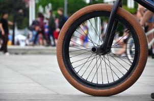 un' bmx bicicletta ruota contro il fondale di un' sfocato strada con Ciclismo cavalieri. estremo gli sport concetto foto