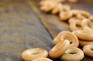 un' lotto di fresco giallo bagel menzogna su il superficie di il vecchio buio Di legno. un' popolare genere di Farina prodotti. uno di il tradizionale russo ossequi per tè foto