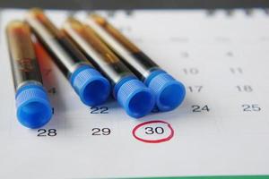 sangue test tubo e calendario su tavolo foto