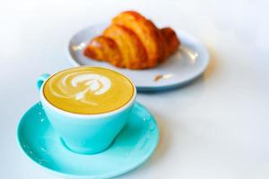 un' verde colore tazza di in ritardo caffè con fiore forma design foto