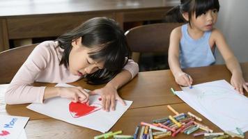 asiatico bambini disegno e pittura su tavolo nel giocando camera a casa, educativo gioco. foto