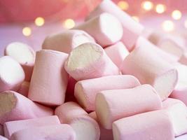 un' avvicinamento foto di un' gustoso rosa-bianco marshmallow con luci su un' sfondo