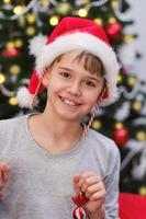 carino divertente bambino con Natale decorazioni su il suo orecchie e nel il suo mani. foto