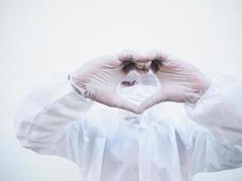 medico o scienziato nel ppe suite uniforme mostrando amore mano cartello. coronavirus o covid-19 con guardare inoltrare isolato bianca sfondo foto