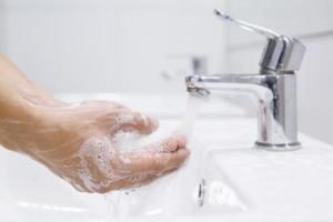 igiene. pulizia mani. lavaggio mani con sapone sotto il rubinetto con acqua pagare sporco. impedire sterilizzare germe batteri patologia. Salute cura concetto. foto