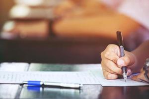 vicino su mani studenti assunzione test esami visita medica valutazioni nel il aula per mossa su nel il ultimo semestre prima la laurea. concetto formazione scolastica. foto