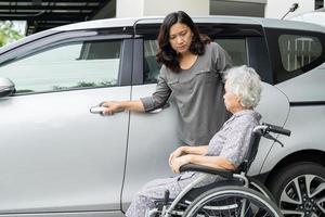 aiutare e supportare la paziente anziana o anziana asiatica anziana prepararsi per raggiungere la sua auto. foto