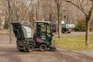 dnepropetrovsk, Ucraina - 22.11.2021 comunale servizio trasporta su di stagione lavori nel il parco. il spazzole spazzare il asfalto. foto