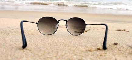 sole bicchieri a il sabbia di il spiaggia vicino il mare foto