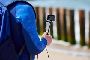 maschio turista registrazione video su azione video telecamera, mano Tenere digitale telecamera, vicino su foto