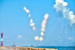 nuvole bianche in fibra di carbonio nel cielo blu che nascondono i cacciatorpediniere navali dai missili anti-nave, spettacolo militare foto