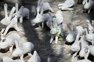 statue di conigli bianchi in gesso alla mostra d'arte all'aperto, divertenti lepri bianche per strada foto