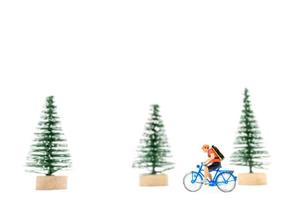miniatura persone con i regali su un' bicicletta su bianca sfondo foto