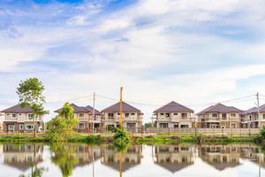 nuovo Casa edificio riflessione con acqua nel lago a Residenziale tenuta costruzione luogo con nuvole e blu cielo foto