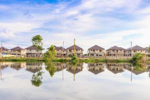 nuovo Casa edificio riflessione con acqua nel lago a Residenziale tenuta costruzione luogo con nuvole e blu cielo foto