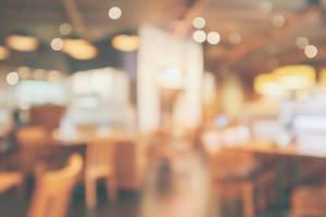 l'interno del ristorante con il cliente e il tavolo in legno sfocano lo sfondo astratto con luce bokeh foto