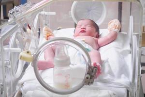 neonato bambino ragazza dentro incubatrice nel ospedale inviare consegna camera foto