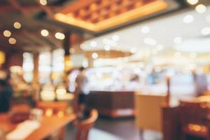 l'interno del ristorante con il cliente e il tavolo in legno sfocano lo sfondo astratto con luce bokeh foto