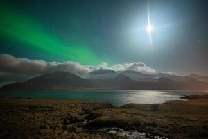 il bellissimo aurora Borealis al di sopra di il montagne fiordo nel piano rialzato di est Islanda. foto