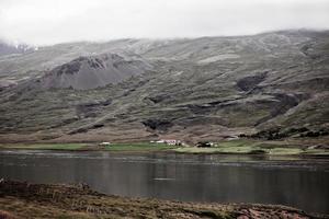 islandese paesaggio con azienda agricola Casa nel nebbioso montagne foto