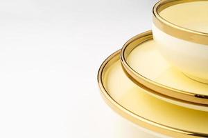 un' avvicinamento tiro di d'oro lusso ceramica cucina utensili su un' bianca sfondo foto