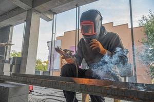 un' Lavorando saldatore fa un' metallo struttura nel un' nuovo edificio infrastruttura foto