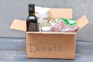 derrata alimentare per donazione. vario cibo, pasta, cucinando olio e in scatola cibo nel cartone scatola. beneficenza cibo banca foto