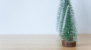 Natale albero su legna tavolo con bianca parete sfondo foto