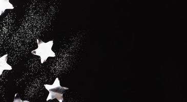 argento stelle coriandoli e scintille su nero sfondo. foto