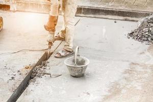 costruzione lavoratore utilizzando martello pneumatico perforazione calcestruzzo superficie foto