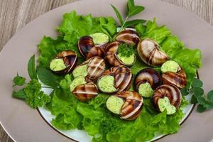 escargot su il piatto e di legno sfondo foto