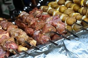 crudo carne e patate siamo piantato su metallo spiedini. il processi di cucinando shish kebab. russo e ucraino campo cibo foto