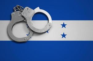 Honduras bandiera e polizia manette. il concetto di crimine e reati nel il nazione foto