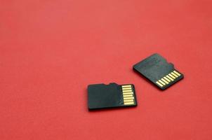 Due piccolo micro sd memoria carte menzogna su un' rosso sfondo. un' piccolo e compatto dati e informazione memorizzare foto