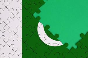 Pakistan bandiera è raffigurato su un' completato sega puzzle con gratuito verde copia spazio su il giusto lato foto