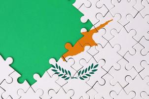 Cipro bandiera è raffigurato su un' completato sega puzzle con gratuito verde copia spazio su il sinistra lato foto