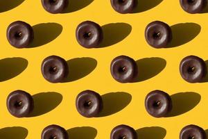 senza soluzione di continuità modello di cioccolato smaltato ciambelle su un' giallo sfondo foto