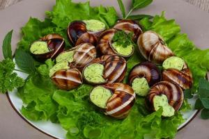 escargot su il piatto e di legno sfondo foto