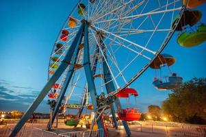 un' attrazione Ferris ruota nel il divertimento parco a notte foto