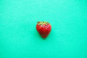 maturo rosso fragola su un' turchese sfondo, superiore Visualizza. salutare estate cibo. foto