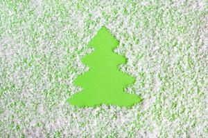 inverno composizione con Natale albero su un' verde sfondo con artificiale neve, piatto posizione. saluto carta per nuovo anno con copia spazio. foto